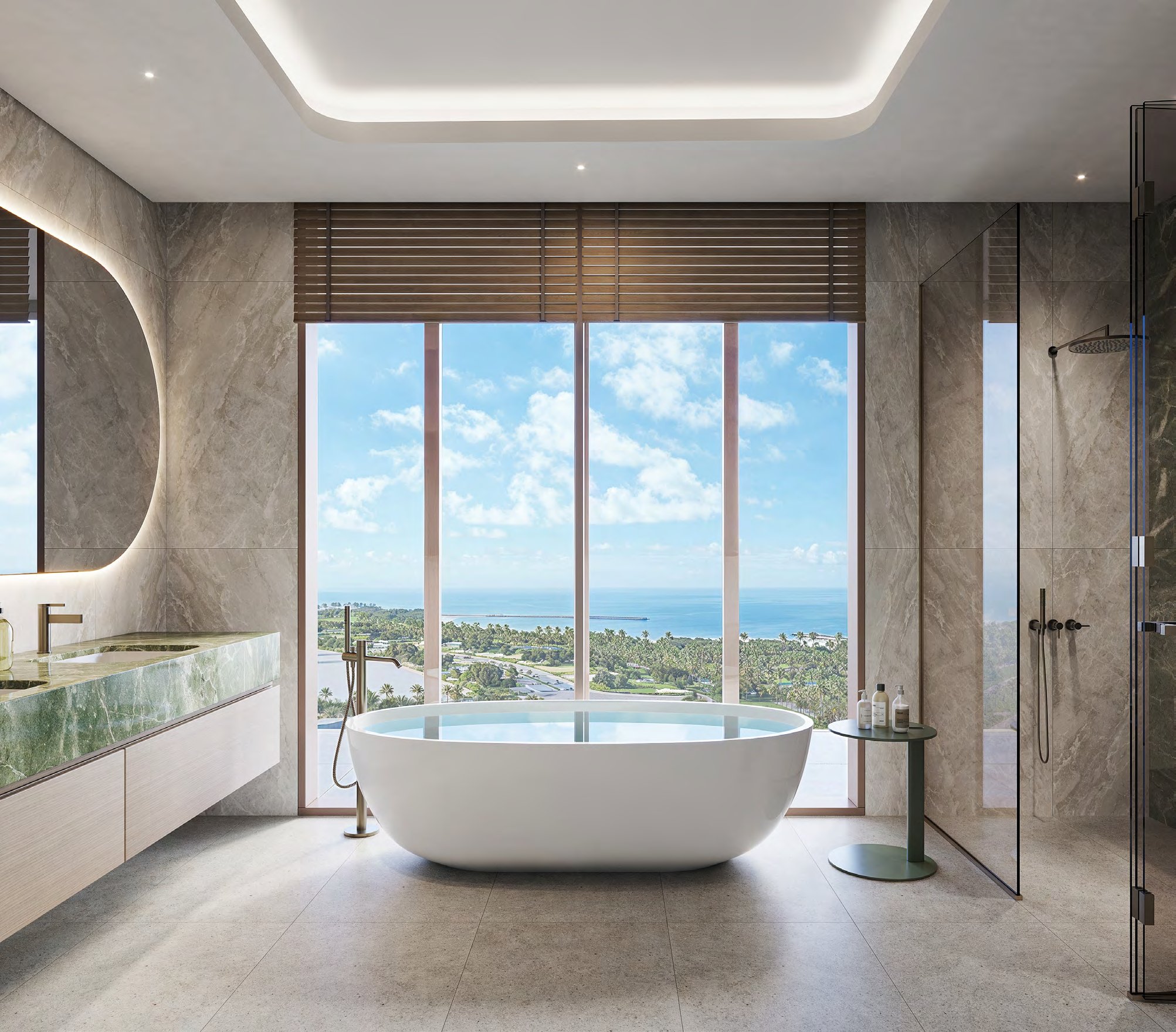 Stone bathroom with freestanding bath before windows looking to the sea