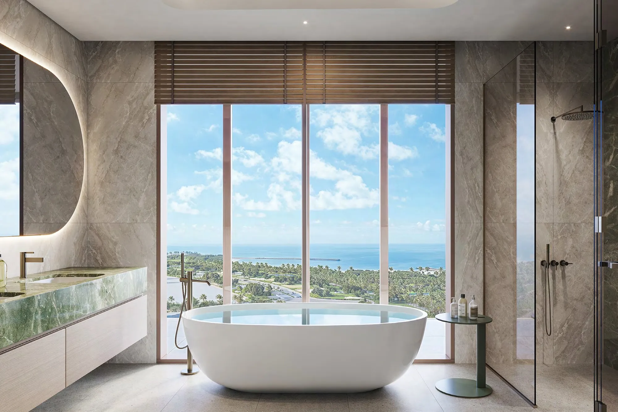 Stone bathroom with freestanding bath before windows looking to the sea